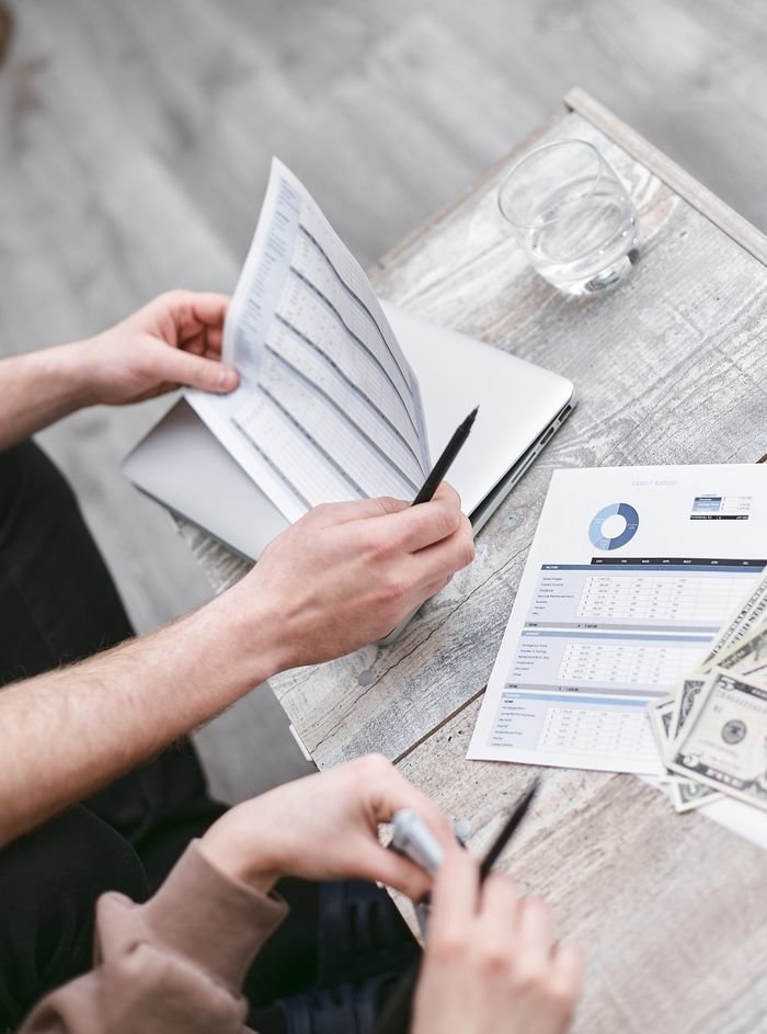 About Two professionals reviewing financial documents with charts, fostering collaboration.