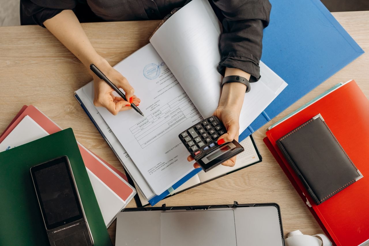 Services Accountant analyzing financial documents with a calculator on a desk, highlighting business tasks.
