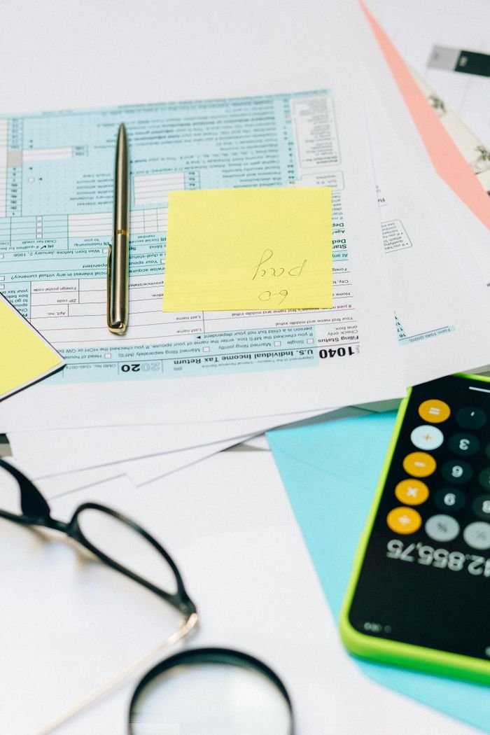 About Close-up of tax documents with a calculator, pen, and notes, ideal for financial content.